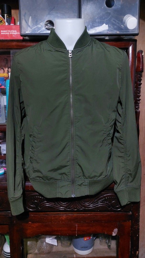 Olive green bomber jacket size L (Category: Coats, Jackets and Outerwear) located in Santa Cruz. Submitted by tovybonacruz (Listing ID 1466595881, Image 2). Description: - Color: Dark olive green - Size: Large (Made in Vietnam) - Closure: Full front zipper - Details: Ribbed collar, cuffs, and hem, with subtle gathering on sleeves - Condition: Clean inside and out, ready to wear.