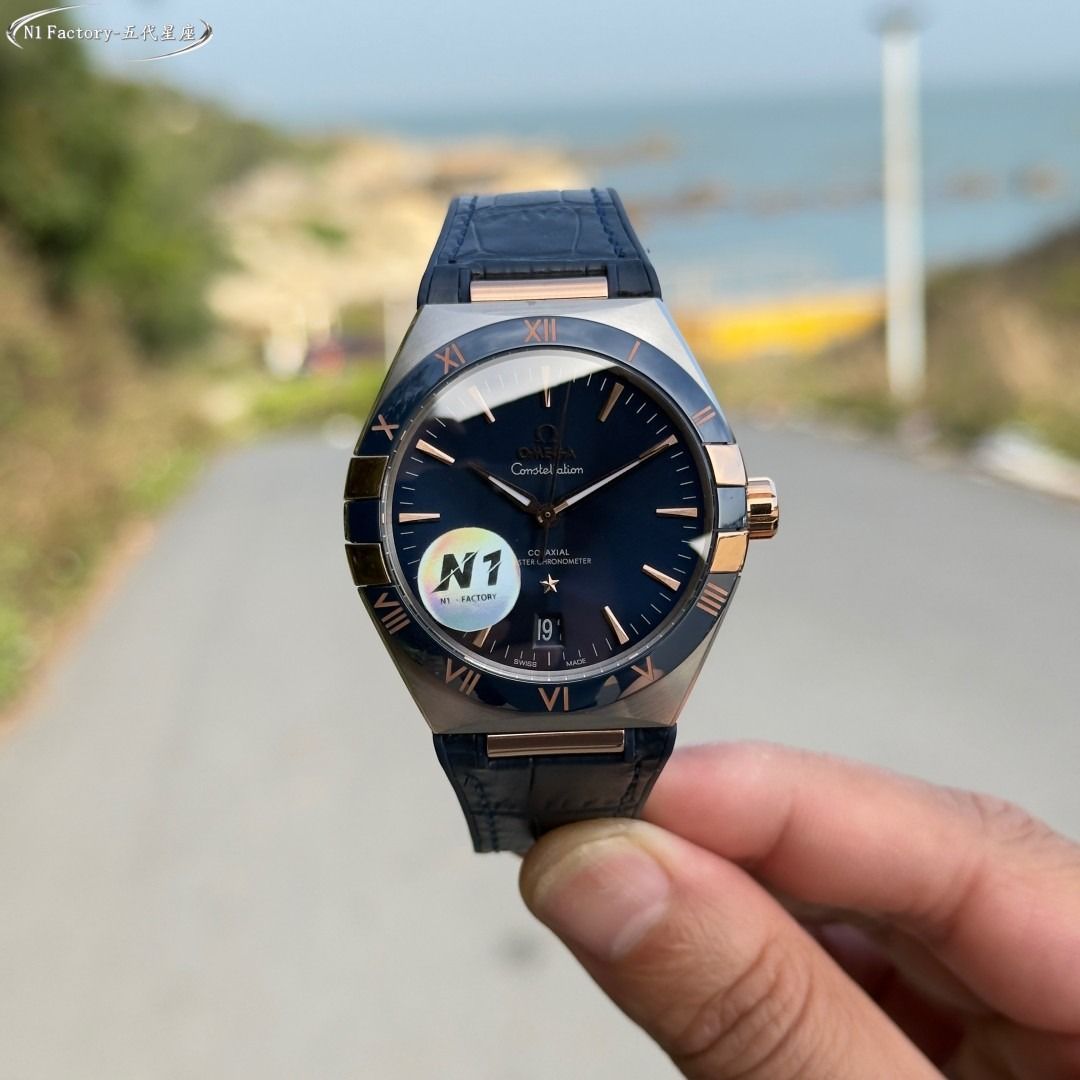 Omega Constellation Co-Axial Master Chronometer Blue Watch (Category: Men's Watches) located in Alabat. Submitted by aynunulema58877 (Listing ID 1466661436, Image 3). Description: Omega Constellation watch with a striking blue dial. Rose gold hands and hour markers pop against the deep blue background. Two-tone steel and rose gold case with matching roman numerals on the bezel. Blue leather strap with alligator texture. Date window positioned at 