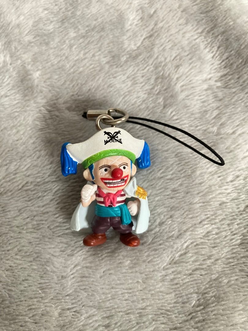 One Piece Buggy the Clown Figure Strap Keychain (Category: Character Goods) located in Rizal. Submitted by sheeraay (Listing ID 1466653620, Image 1). Description: - Character: Buggy the Clown from One Piece - Design: Marine captain outfit with white coat - Features: Includes black strap attachment and official copyright stamp on the back - Condition: Clean paint work and great overall condition - Type: Mini figure keychain.