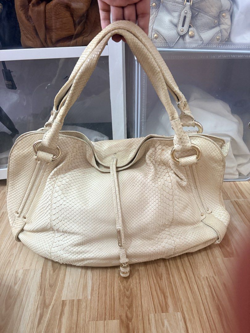 ORIGINAL Celine Off-White Phy Leather Handbag (Category: Luxury Bags & Wallets) located in Bacoor. Submitted by preownedparadyse (Listing ID 1466753323, Image 1). Description: - Brand: Celine - Material: Cream-colored python snakeskin texture - Hardware: Gold-tone rings and metal clasp - Design: Dual top handles, distinctive vertical front strap, structured slouchy silhouette - Condition: Natural scaling and soft wear consistent with regular hand