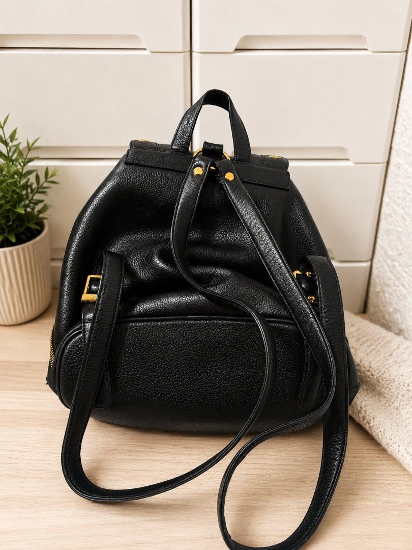 Original MCM Backpack (Category: Backpacks) located in Manila. Submitted by coolbear.5772e6 (Listing ID 1466731853, Image 2). Description: Highlights - black - leather - grained texture - gold-tone stud embellishment - foldover top - magnetic fastening - drawstring fastening - single flat top handle - two adjustable shoulder straps - front flap pocket - internal zip-fastening pocket gold-tone hardware Condition: GOOD. This previously owned and us