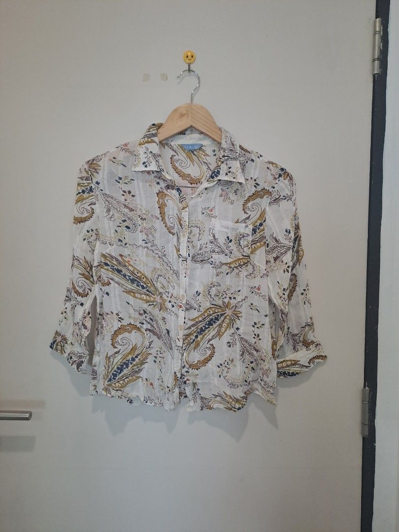 Paisley longsleve (Category: Longsleeves) located in Manila. Submitted by joanbalde39643 (Listing ID 1466666745, Image 1). Description: The image shows a white button-up shirt featuring a multicolor paisley print, a classic collar, a chest pocket, and three-quarter sleeves..