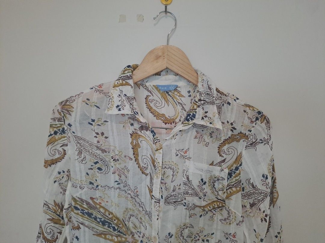 Paisley longsleve (Category: Longsleeves) located in Manila. Submitted by joanbalde39643 (Listing ID 1466666745, Image 3). Description: The image shows a white button-up shirt featuring a multicolor paisley print, a classic collar, a chest pocket, and three-quarter sleeves..