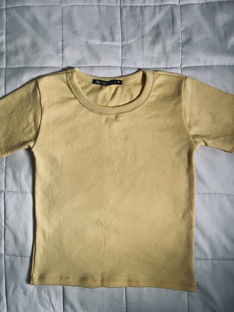Pastel Yellow Ribbed Crop Top (Size S) (Category: Shirts) located in Davao. Submitted by curatedcloset.dvo (Listing ID 1466650312, Image 2). Description: • Brand: No Brand / Unbranded (Zara style) • Size: Small (S) on tag • Color: Pastel Soft Yellow • Condition: 10/10 excellent condition. The fabric is a thick, highly flexible ribbed knit material that fits beautifully and is super comfortable for daily wear. No stains or loose threads! 💡 PROMO: