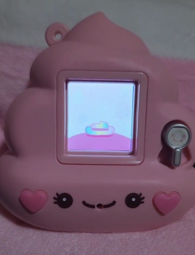 Pink Poop Shape Virtual Pet Toy (Category: Interactive Toys) located in Quezon City. Submitted by peachhalves (Listing ID 1466633799, Image 2). Description: Happinet Fuwatcho Uncho Fuwa Fuwa Pink Virtual Pet Description: Selling this authentic Happinet Fuwatcho Uncho Fuwa Fuwa pink virtual pet (the famous Japanese interactive cute poop toy!). • Condition: Gently used, fully functional, and working perfectly as shown in the picture. very cute🤩 DM