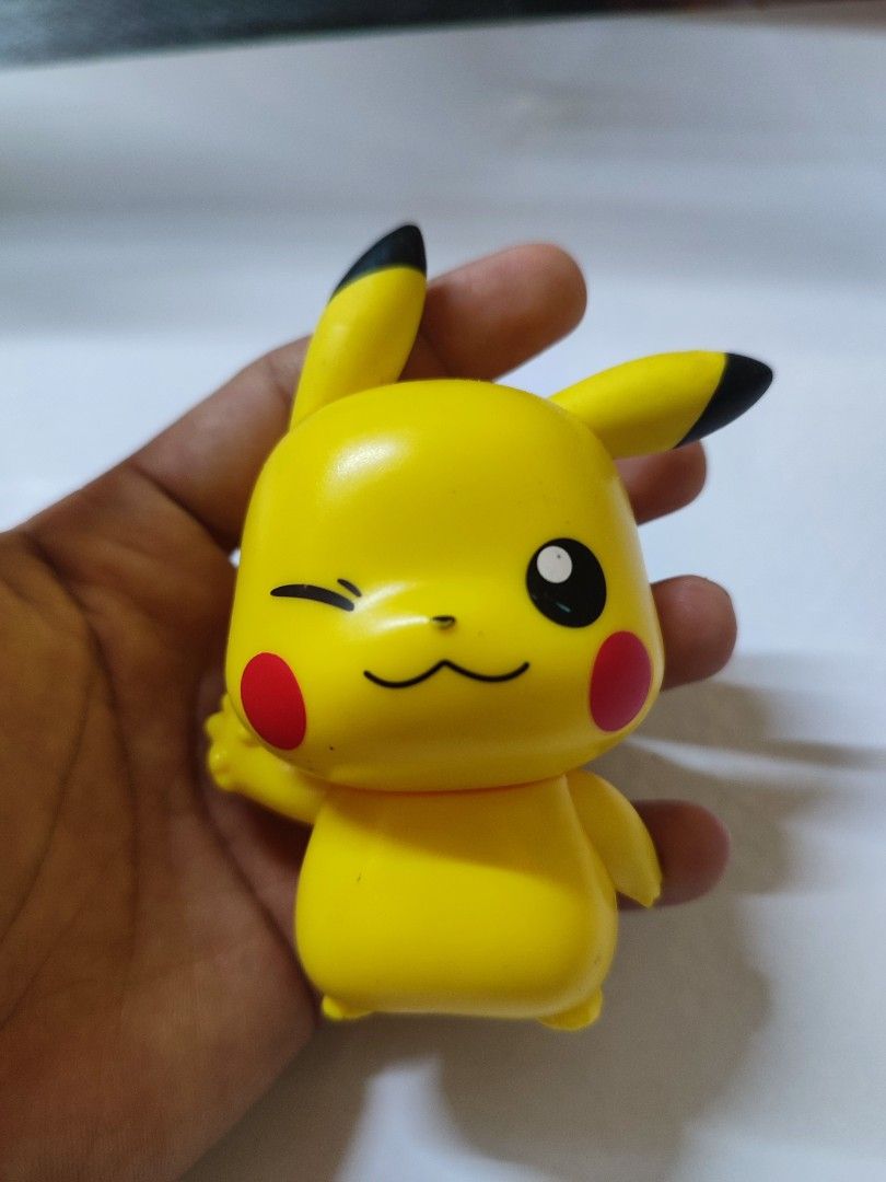 Pokemon Pikachu Figurine Winking Face (Category: Figurines & Statues) located in Manila. Submitted by shop_eyy (Listing ID 1466616843, Image 1). Description: - Character: Pikachu from Pokémon - Design: Playful winking face, brown stripes on back, black-tipped ears - Material: Smooth matte finish vinyl - Features: Handheld size and stands on its own - Condition: Lightly used collectible condition - Perfect gift for Pokémon collectors and fans!.