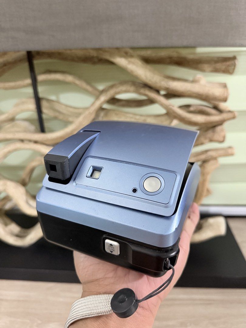Polaroid one600 Instant Film Camera (Category: Cameras) located in Pasig City. Submitted by iambernabe (Listing ID 1466713003, Image 3). Description: - Model: Polaroid one600 Instant Film Camera - Color: Blue and silver colorway - Lens: 100mm focus lens (ranges from 3 feet to infinity) - Flash: Built-in flash for low-light shooting - Film Type: Uses standard 600 type film - Extras: Original strap attached to the side - Condition: Clean body with 