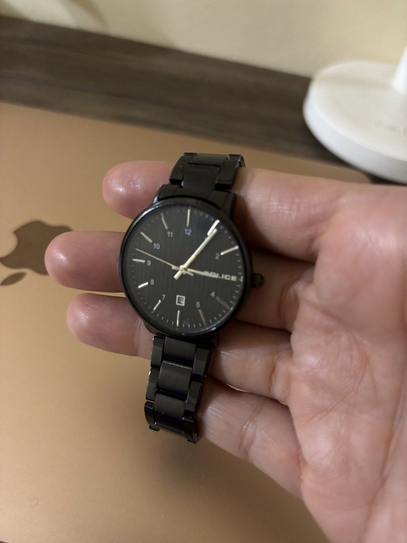 Police female watch (Category: Wearables & Smart Watches) located in Balayan. Submitted by authenticfindsbymrb (Listing ID 1466714722, Image 2). Description: - Brand: Police - Color: All-black (dial, case, and metal strap) - Features: Round dark face with white numerals/hands and date display window - Clasp: Secure fold-over clasp with engraved logo - Condition: 8/10, well-maintained with light signs of wear - Style: Versatile, sleek, and edgy ev