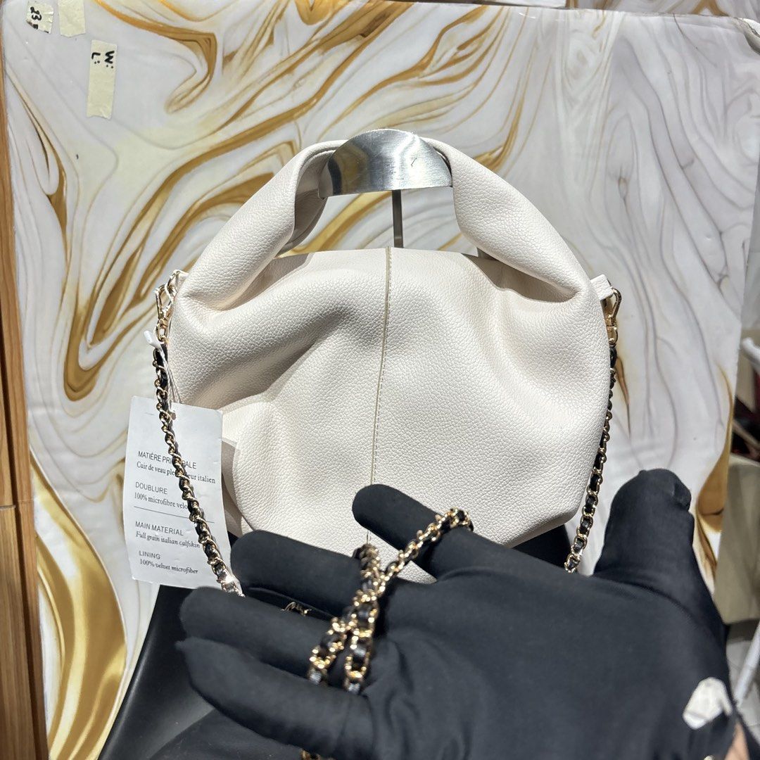 Polène White Leather Handbag with sling (Category: Luxury Bags & Wallets) located in Bambang. Submitted by heats777 (Listing ID 1466662910, Image 3). Description: - Brand: Polène - Color/Material: Textured white full-grain Italian calfskin - Hardware: Gold-tone - Interior: Velvet microfiber lining with brand label and serial number 11554 - Strap/Handles: Chain strap and gathered top handles - Origin: Made in Spain - Condition: Tag attached, spaci