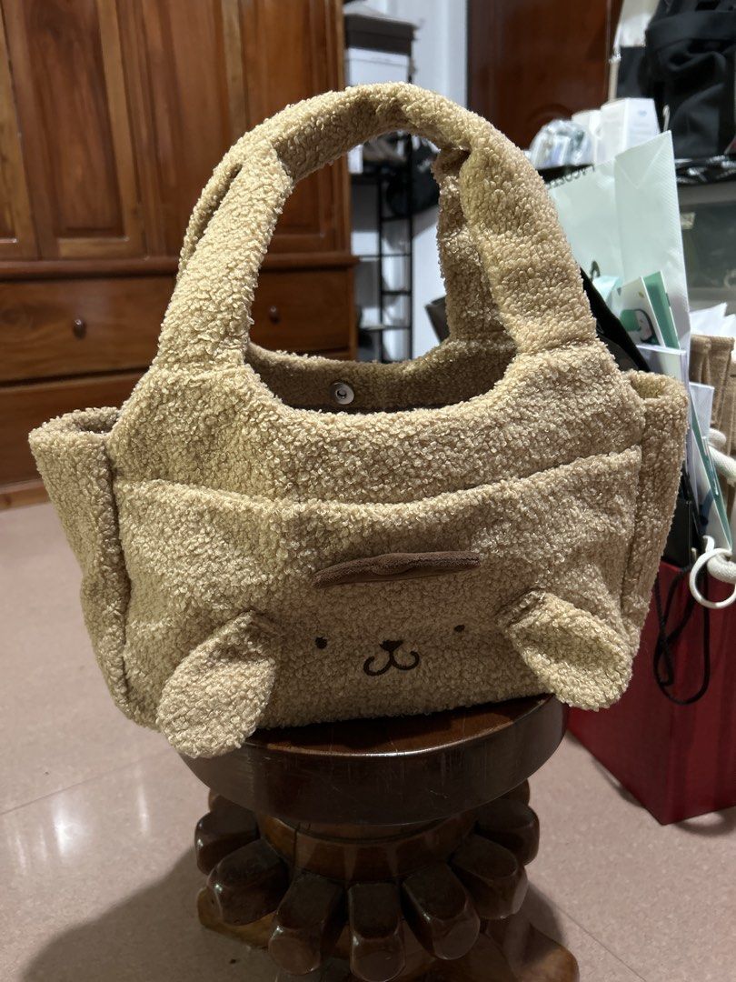 Pompompurin Fluffy Sherpa Tote Bag (Category: Tote Bags) located in Alitagtag. Submitted by patrickvillanueva (Listing ID 1466629952, Image 2). Description: I bought this from Japan Fuzzy Pompompurin tote bag in beige sherpa material. Brown embroidered face details with floppy ears on the front, plus a label patch on the back. Smooth lining inside with open main compartment and sturdy handles. Soft textured fabric all over..