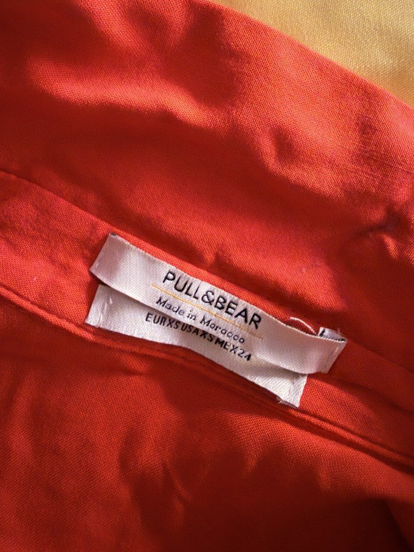 Pull&Bear Orange Short Sleeve Shirt Size XS (Category: Shirts) located in Quezon City. Submitted by makingroomfinds (Listing ID 1466588255, Image 2). Description: 👚Bright orange button-up top from Pull&Bear 👚Short sleeves, lapel collar, tie-front hem detail. 👚Elastic band across the back hem. Made in Morocco. 👚Size EUR XS, USA XS, MEX 24..