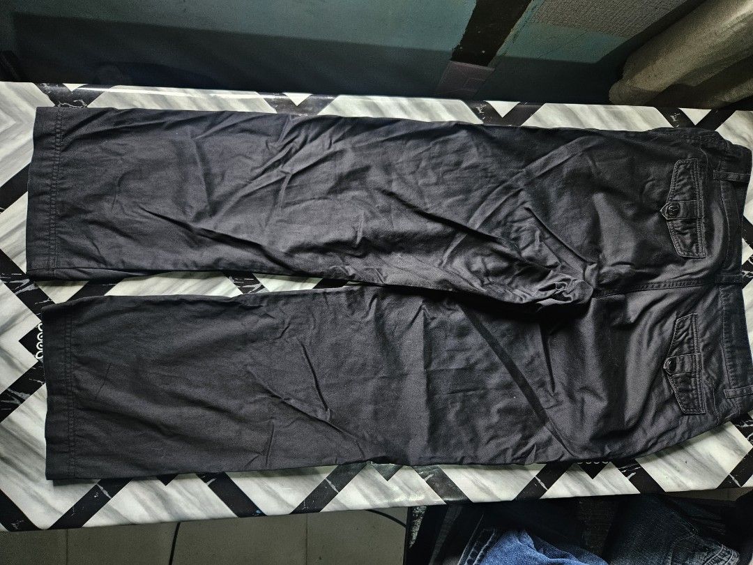 Puma Black Casual Pants Trousers (Category: Joggers) located in Manila. Submitted by shanshan.river (Listing ID 1466592743, Image 2). Description: - Brand: Puma - Color: Black - Fit: Straight leg, regular length - Details: Side pockets, back pockets with button flaps, button closure - Branding: Embroidered white Puma cat logo on upper leg - Fabric: Mid-weight, great for everyday casual wear - Condition: Excellent.