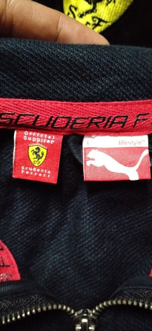 Puma Scuderia Ferrari Zip Jacket and Cap (Category: Coats, Jackets and Outerwear) located in Paranaque City. Submitted by michael-08 (Listing ID 1466755663, Image 2). Description: - Authentic Puma Scuderia Ferrari bundle: Jacket and matching cap - Color: Sleek black with bold red piping details - Jacket Size: Large (L) - Branding: Official Ferrari tags, branded zipper pulls, and embroidered shield patches on both chest and cap - Bonus: Shell Heli