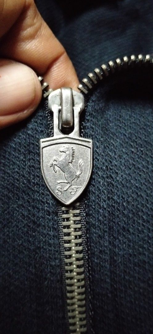 Puma Scuderia Ferrari Zip Jacket and Cap (Category: Coats, Jackets and Outerwear) located in Paranaque City. Submitted by michael-08 (Listing ID 1466755663, Image 3). Description: - Authentic Puma Scuderia Ferrari bundle: Jacket and matching cap - Color: Sleek black with bold red piping details - Jacket Size: Large (L) - Branding: Official Ferrari tags, branded zipper pulls, and embroidered shield patches on both chest and cap - Bonus: Shell Heli