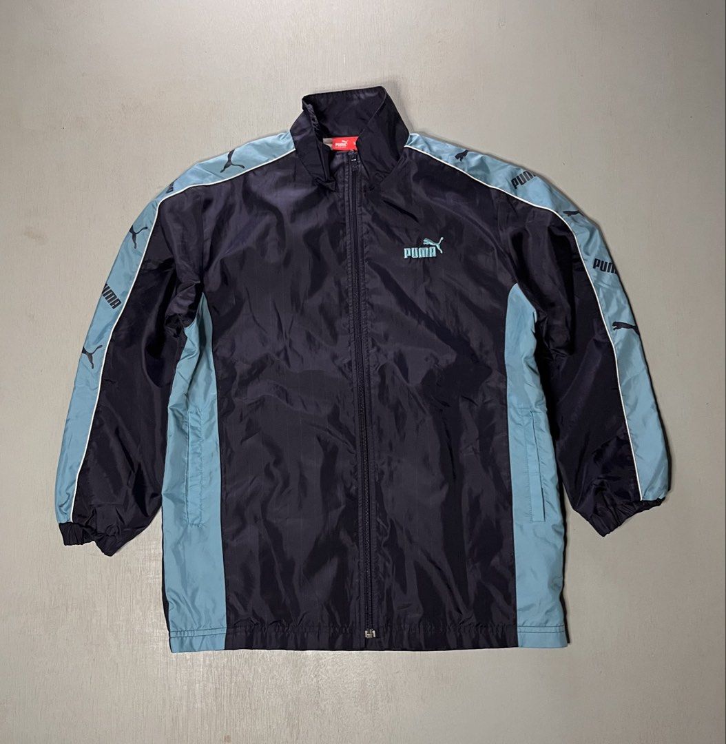 Puma Track Jacket Navy Light Blue Size 150 (Category: Coats, Jackets and Outerwear) located in Catbalogan. Submitted by yellfindss (Listing ID 1466740981, Image 1). Description: - Brand: Puma -20/26 - Color: Navy blue with light blue side panels and sleeve tape - Details: Embroidered light blue Puma logo on chest, full zip front, high collar - Texture: Subtle vertical stripe texture throughout - Size: 150 (indicated on red inner neck tag) - Origi