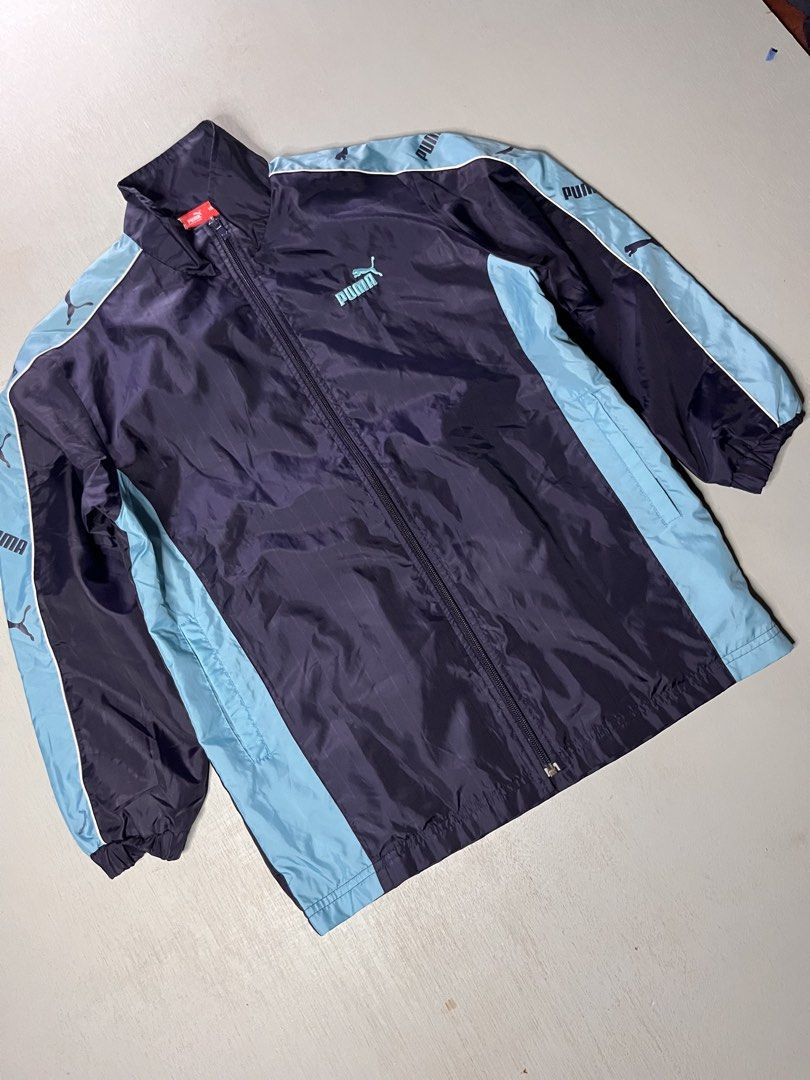 Puma Track Jacket Navy Light Blue Size 150 (Category: Coats, Jackets and Outerwear) located in Catbalogan. Submitted by yellfindss (Listing ID 1466740981, Image 3). Description: - Brand: Puma -20/26 - Color: Navy blue with light blue side panels and sleeve tape - Details: Embroidered light blue Puma logo on chest, full zip front, high collar - Texture: Subtle vertical stripe texture throughout - Size: 150 (indicated on red inner neck tag) - Origi