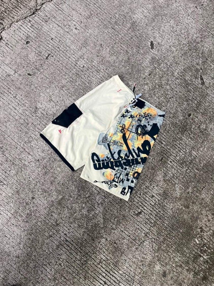 Quiksilver Board Shorts Surf Swim Trunks (Category: Swim Trunks & Board Shorts) located in Sipalay. Submitted by yon.thrifter (Listing ID 1466773281, Image 2). Description: - Brand: Quiksilver - Dimension: W34 L22 - Design: Unique split design (cream side + bold black, yellow, and grey graphic side) - Features: Drawstring waist with contrast eyelets and eye-catching leg graphics - Storage: Convenient side cargo pocket with an included surf wax co