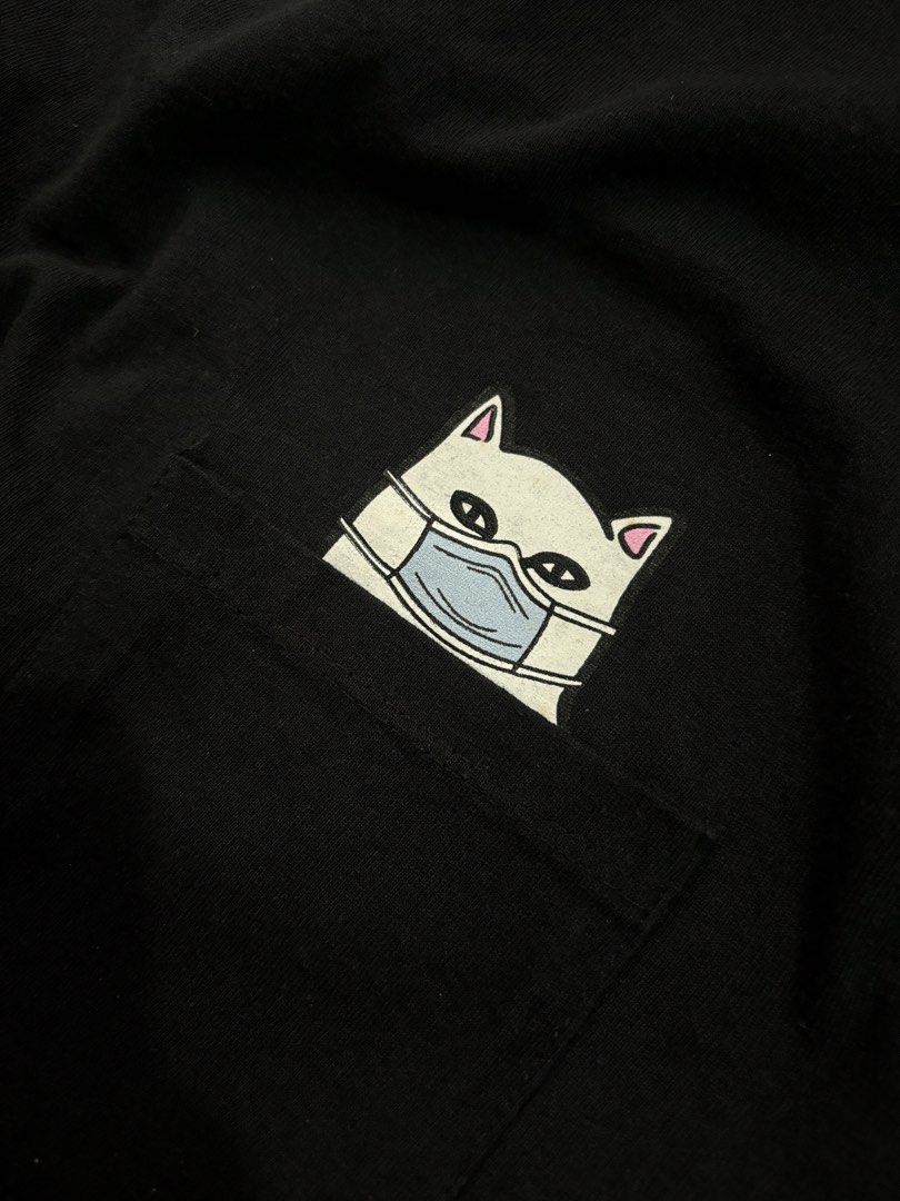 RIPNDIP Lord Nermal Pocket Tee Black Size L (Category: Tshirts & Polo Shirts ) located in Taguig. Submitted by j.gloria (Listing ID 1466702682, Image 2). Description: - Brand: RIPNDIP - Color: Black - Size: Large - Design: Lord Nermal peeking out of chest pocket with blue face mask and middle finger - Condition: Clean fabric, excellent streetwear staple - Styling: Easy to pair with jeans or cargo pants.