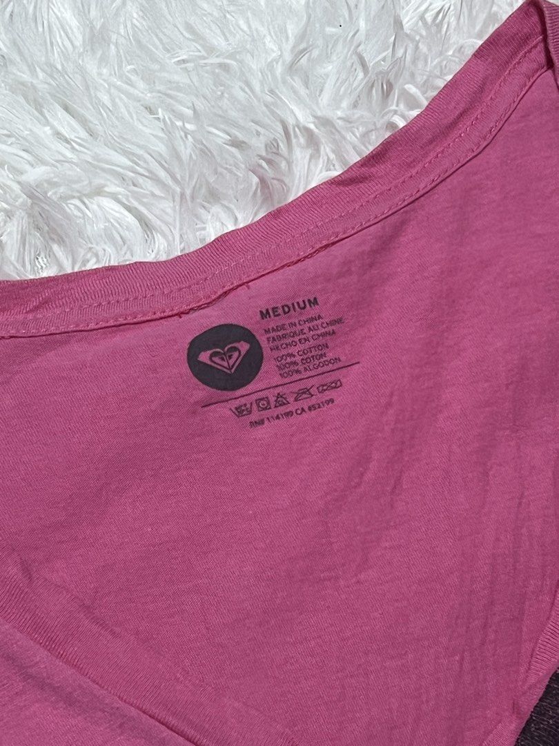 Roxy Pink Hawaii Graphic V-Neck Tee Medium (Category: Shirts) located in Tuguegarao City. Submitted by love_clothies (Listing ID 1466605476, Image 3). Description: - Brand: Roxy - Color: Pink with black heart and Hawaii graphic - Size: Medium - Material: 100% cotton (soft and breathable) - Fit: Standard fit with short sleeves - Care: Machine washable - Condition: Excellent / Pre-loved - Size: Small to Medium.
