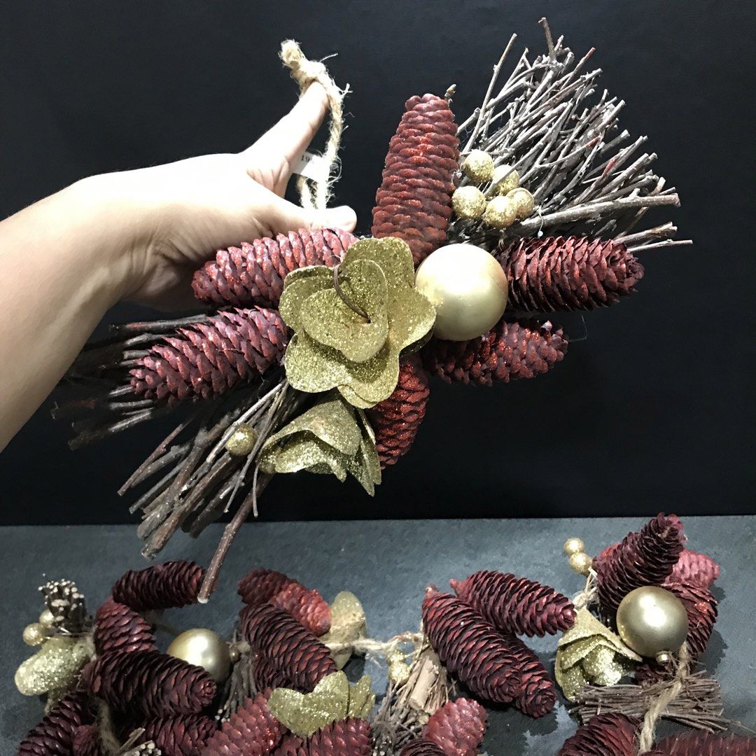 Rustic Pine Cone Christmas Wreath with Gold Ornaments (Category: Wall Decor) located in Baao. Submitted by all.things.japan (Listing ID 1466715011, Image 3). Description: - Festive holiday wreath featuring dried twigs, dark red pine cones, and metallic gold flowers - Accented with shiny gold baubles and glittery berry clusters - Equipped with a rustic jute string loop for effortless hanging on doors or walls - Ideal for adding a touch of Christma
