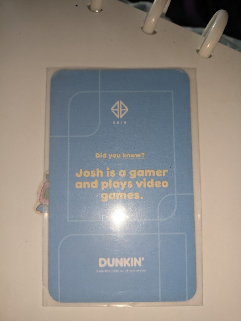 SB19 Josh Dunkin Photocard (Category: K-Wave Merchandise) located in Manila. Submitted by silenthawk_b2544d (Listing ID 1466599736, Image 2). Description: - Official SB19 x Dunkin collaboration photocard - Variant: Josh (Blue background, orange shirt, holding a game controller) - Back design: SB19 logo, Dunkin branding, and Josh's gamer fun fact - Size: Standard photocard size with rounded corners - Condition: Mint, kept in a clear sleeve for pro