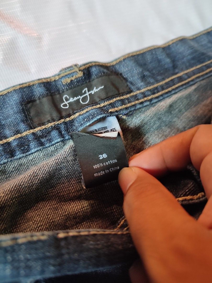 Sean John Dark Blue Denim Jeans Size 36 (Category: Jeans) located in Puerto Princesa. Submitted by thriftedsoulsy2k (Listing ID 1466600964, Image 3). Description: - Brand: Sean John - Size: 36 - Material: 100% Cotton (Made in China) - Fit: Classic fit with metal button closure - Details: Contrast stitching, stylish graphic print on right leg and back pocket, and leather brand patch - Condition: Good everyday denim, ready to wear.
