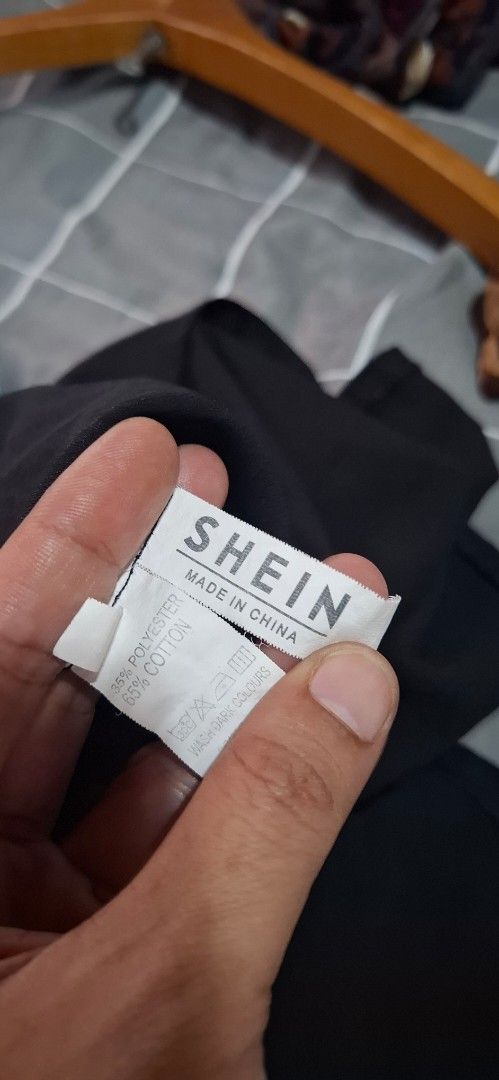 SHEIN Black Short Sleeve Button-Up Shirt (Category: Shirts) located in Cabuyao City. Submitted by gaile29 (Listing ID 1466623590, Image 3). Description: Black short sleeve button-up shirt from SHEIN. Features a collar, chest pocket, and white buttons down the front. Material tag shows 65% cotton and 35% polyester. Made in China. Easy to style with denim or trousers..