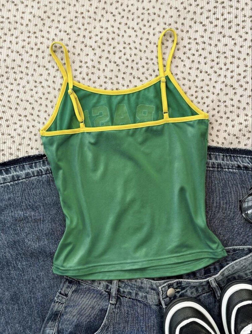 Shein Green Cami Cropped Tank Top (Category: Sleeveless) located in Manila. Submitted by dianafayesimbre (Listing ID 1466770968, Image 2). Description: - Color: Green with yellow trim - Design: Bold 'BRASIL' lettering, flag print, and 'SOUTH AMERICA' text - Fit: Fitted style with adjustable straps - Material: Lightweight and comfortable fabric - Styling: Great for casual wear, denim shorts, or skirts.