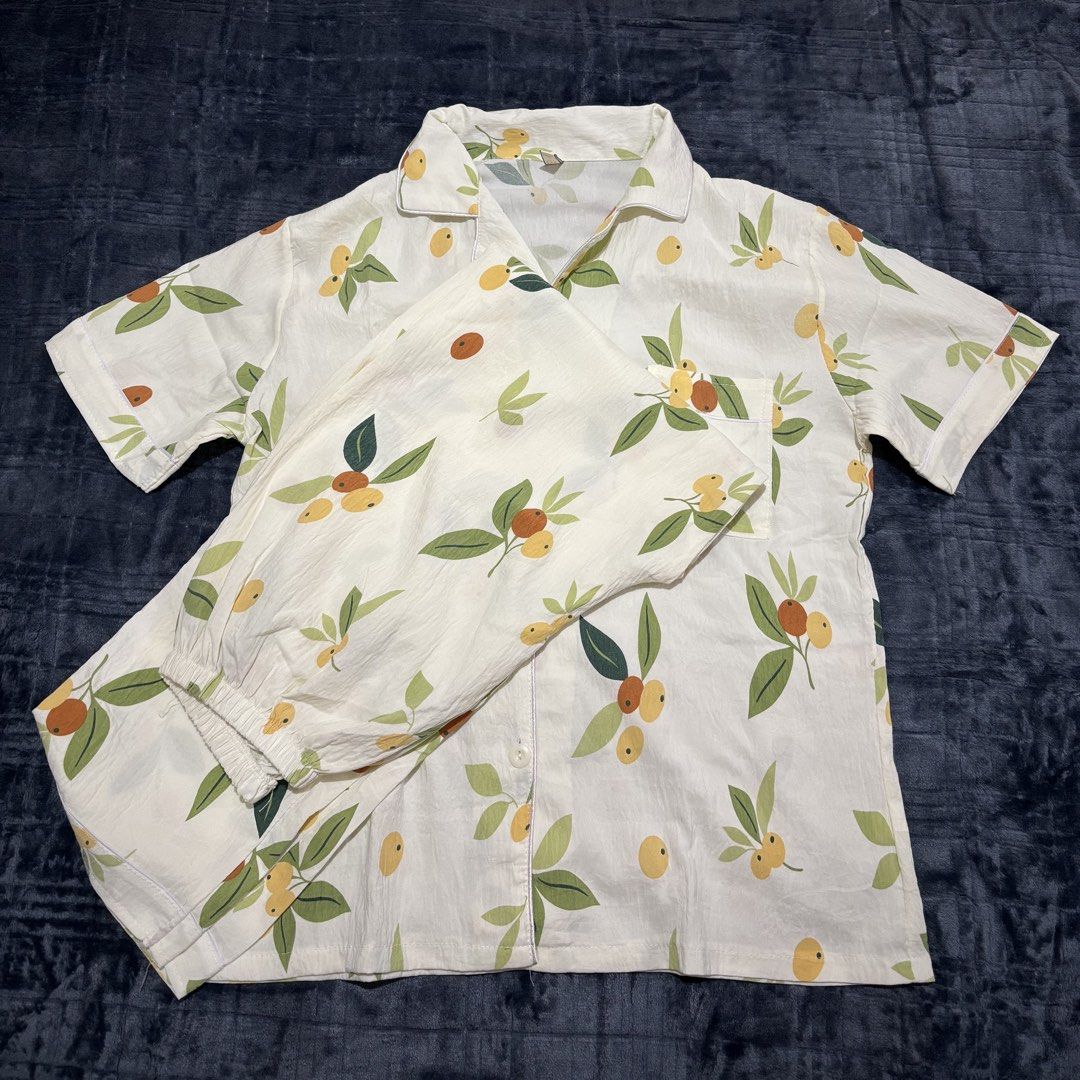 Short sleeve button down pajama set with fruit print (Category: Undergarments & Loungewear) located in Balayan. Submitted by authenticfindsbymrb (Listing ID 1466709764, Image 1). Description: - Design: Off-white matching set with green leaves and yellow/brown fruit print - Top: Short-sleeve button-down with chic lapel collar and chest pocket - Bottoms: Pants equipped with a comfortable elastic waistband - Material: Lightweight and breathable, ide