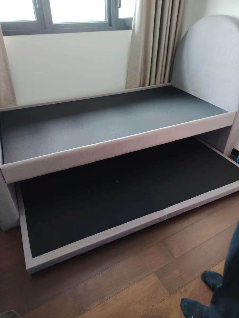 single bed (Category: Bed Frames & Mattresses) located in Singapore. Submitted by vivianhousegoods (Listing ID 1466624481, Image 1). Description: - Grey upholstered single bed frame - Includes a pull-out trundle bed for extra sleeping space - Great space-saving option for guest rooms or kids' bedrooms.