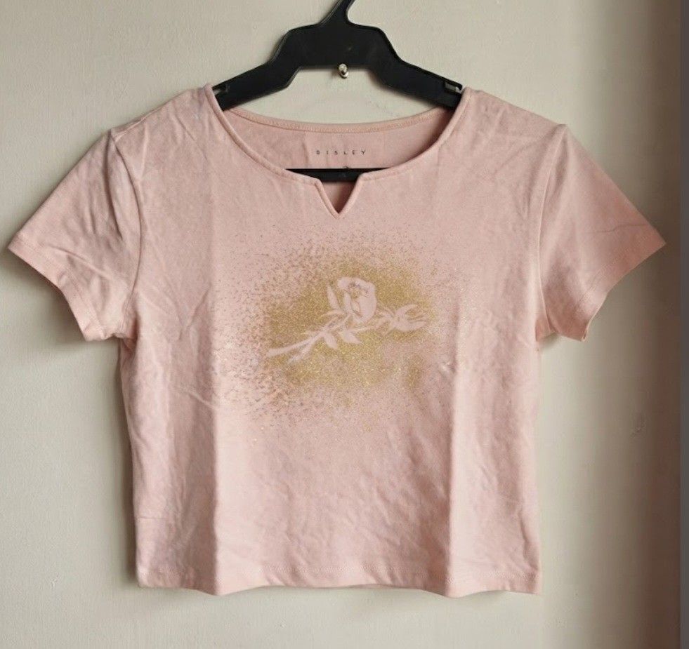 SISLEY METALLIC GRAPHIC CROPPED TEE, PINK-SMALL (Category: Shirts) located in Quezon City. Submitted by carsenmktg (Listing ID 1466748932, Image 2). Description: SISLEY METALLIC GRAPHIC CROPPED TEE, PINK-SMALL guaranteed authentic. brand new without tags. Sisley ​Origin: Made in Italy ​Color: Light pink / pastel pink with a gold foil graphic Size: small ​Design & Features ​Neckline: V-notch neckline (or split neckline) with short sleeves. ​Graphi