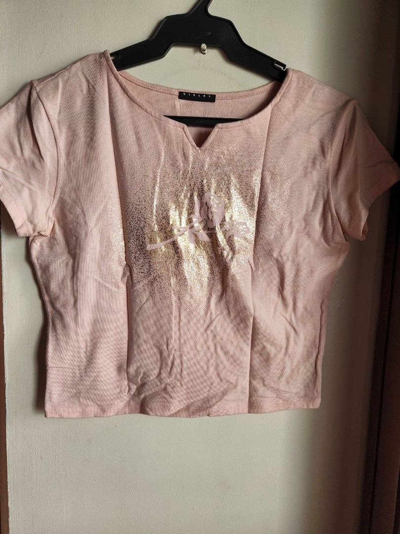 SISLEY METALLIC GRAPHIC CROPPED TEE, PINK-SMALL (Category: Shirts) located in Quezon City. Submitted by carsenmktg (Listing ID 1466748932, Image 3). Description: SISLEY METALLIC GRAPHIC CROPPED TEE, PINK-SMALL guaranteed authentic. brand new without tags. Sisley ​Origin: Made in Italy ​Color: Light pink / pastel pink with a gold foil graphic Size: small ​Design & Features ​Neckline: V-notch neckline (or split neckline) with short sleeves. ​Graphi
