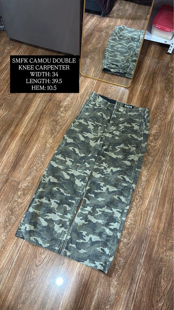 SMFK Camou Double Knee Carpenter Pants (Category: Jeans) located in Batangas. Submitted by franzbucal (Listing ID 1466609192, Image 1). Description: - Brand: SMFK - Style: Camouflage double knee carpenter pants - Color: Green and grey camo print - Fit: Relaxed straight leg - Details: Utility cargo pockets and hammer loop - Measurements: Width 34" | Length 39.5" | Hem 10.5" - Condition: Solid construction, great streetwear piece.