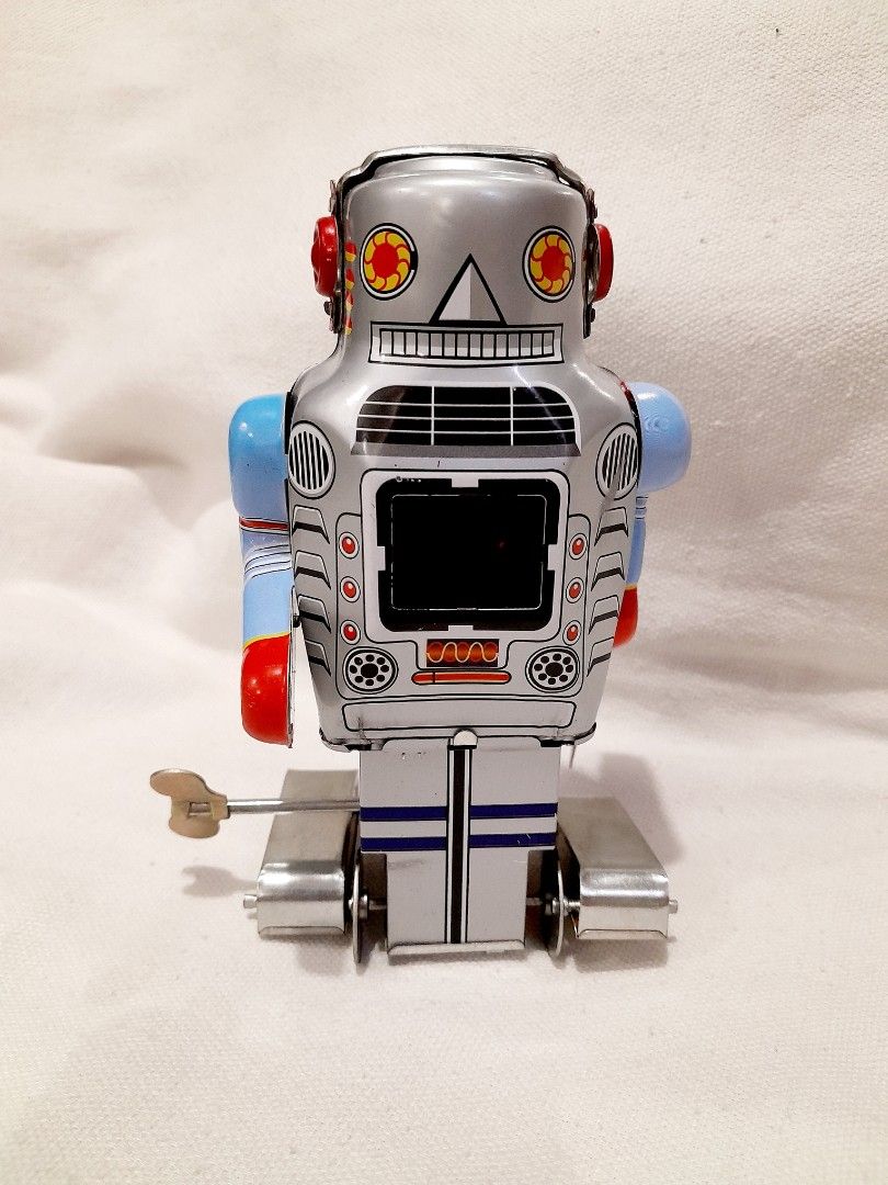 Spark Wind Up Robot (Category: Vintage Collectibles) located in Quezon City. Submitted by ebuenvenida737 (Listing ID 1466605540, Image 1). Description: - Type: Wind-up tin robot collector's item - Design: Silver body with blue arms, red details, and retro control panel graphics on chest and back - Mobility: Built-in wind-up mechanism with included key for working movement - Base: Classic metal tracks on the bottom.