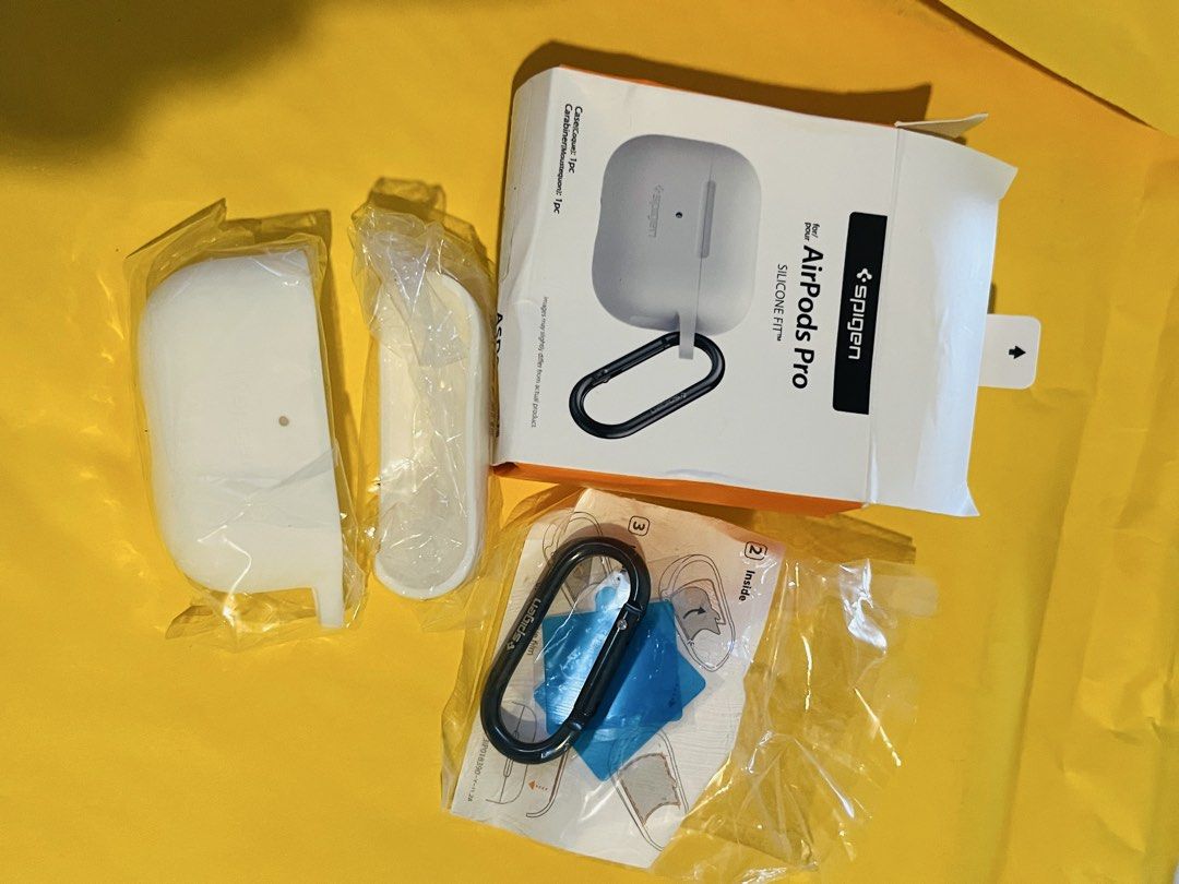 Spigen Silicone Fit AirPods Pro Case (Category: Cases & Sleeves) located in Malabon City. Submitted by mgsurplus (Listing ID 1466565500, Image 2). Description: - Brand: Spigen - Compatibility: AirPods Pro - Color: White with a smooth matte finish - Inclusions: Black metal carabiner clip and original packaging.