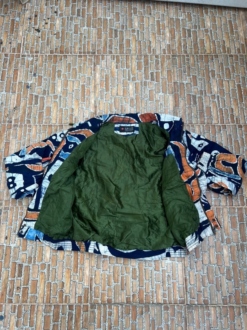 Splendour Abstract Print Bomber Jacket Size M (Category: Coats, Jackets and Outerwear) located in Caloocan City. Submitted by sillapwet0606 (Listing ID 1466564629, Image 3). Description: - Brand/Model: Splendour jacket - Size: Medium (M) - Design: Dark blue base with heavy white and orange abstract art patterns - Interior: Vibrant green lining inside the body and Chinese text on the brand tag - Features: Elastic hem and cuffs for a comfortable fi