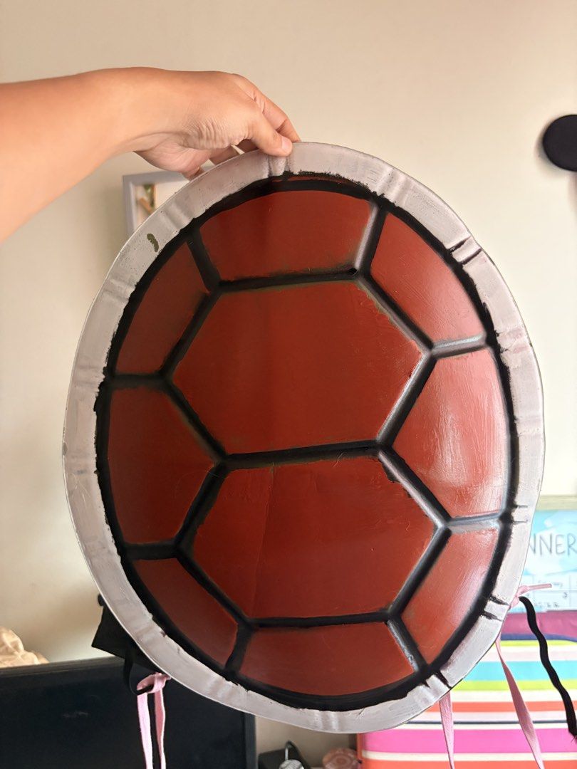 Squirtle turtle shell cosplay prop costume accessory (Category: Character Goods) located in Quezon City. Submitted by edfghjklnncpl (Listing ID 1466623021, Image 2). Description: Handmade turtle shell prop, great for Squirtle cosplay or Pokémon costumes. Red hexagonal plates with black borders and a white rim. Worn once for a photoshoot, fits comfortably on the back with straps attached. Lightweight and sturdy build. Ready for your next conventio