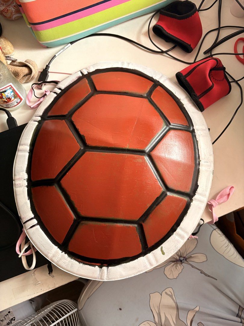 Squirtle turtle shell cosplay prop costume accessory (Category: Character Goods) located in Quezon City. Submitted by edfghjklnncpl (Listing ID 1466623021, Image 1). Description: Handmade turtle shell prop, great for Squirtle cosplay or Pokémon costumes. Red hexagonal plates with black borders and a white rim. Worn once for a photoshoot, fits comfortably on the back with straps attached. Lightweight and sturdy build. Ready for your next conventio