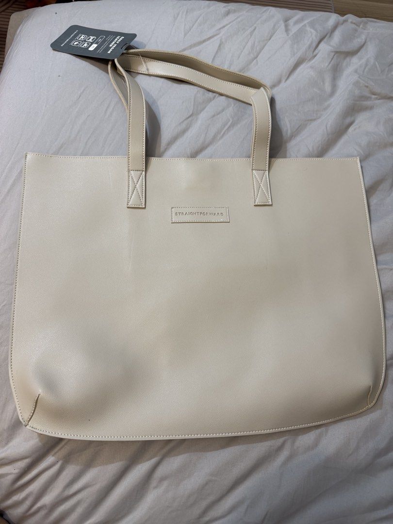 Straightforward Daily Vegan Leather Tote Bag (Category: Tote Bags) located in Trece Martires City. Submitted by wildshark554 (Listing ID 1466729471, Image 3). Description: - Condition: Brand new with tags attached - Material: Durable, water-resistant vegan leather - Design: Clean minimalist style with an embossed front logo and double shoulder straps - Colors available: Maroon, beige, brown, and tan - Perfect for daily use and work.