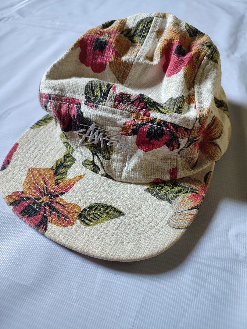 Stüssy Floral Pattern 5-Panel Cap (Category: Caps & Hats) located in Puerto Princesa. Submitted by thriftedsoulsy2k (Listing ID 1466600458, Image 1). Description: - Brand: Stüssy - Design: All-over floral print in cream, pink, and green - Material: Textured woven fabric - Embroidery: White Stüssy logo on the front panel - Closure: Adjustable black strapback with logo tab - Details: Interior Stüssy Capz branding with RN 94974 and CA 28629 tags - C