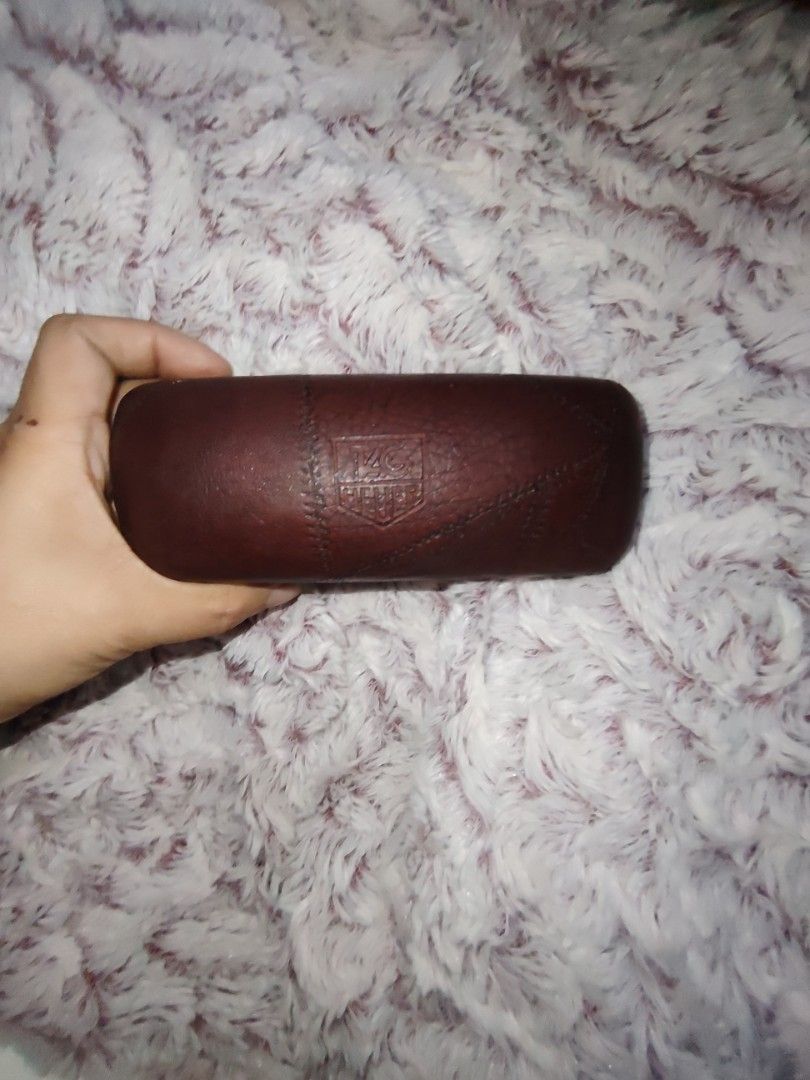 TAG Heuer Brown Leather Eyewear Case (Category: Luxury Accessories) located in Manila. Submitted by purediamond888 (Listing ID 1466758911, Image 1). Description: Brown leather glasses case from TAG Heuer. Embossed logo on front and stitched pattern detailing. Inside has a light-colored lining with the brand logo stamped on the upper lid. Snap closure keeps sunglasses or spectacles secure..