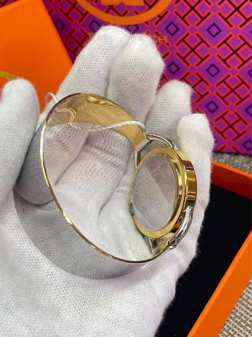 TB Gold Bangle Watch with White Dial (Category: Women's Watches) located in Manila. Submitted by bagsandmanymanymore1 (Listing ID 1466585876, Image 3). Description: - Brand: TB Bangle Watch - Style: Gold-tone bangle cuff watch with secure closure - Dial: White dial with iconic double T logo pattern - Condition/Inclusions: Comes with original orange presentation box and swing tag .