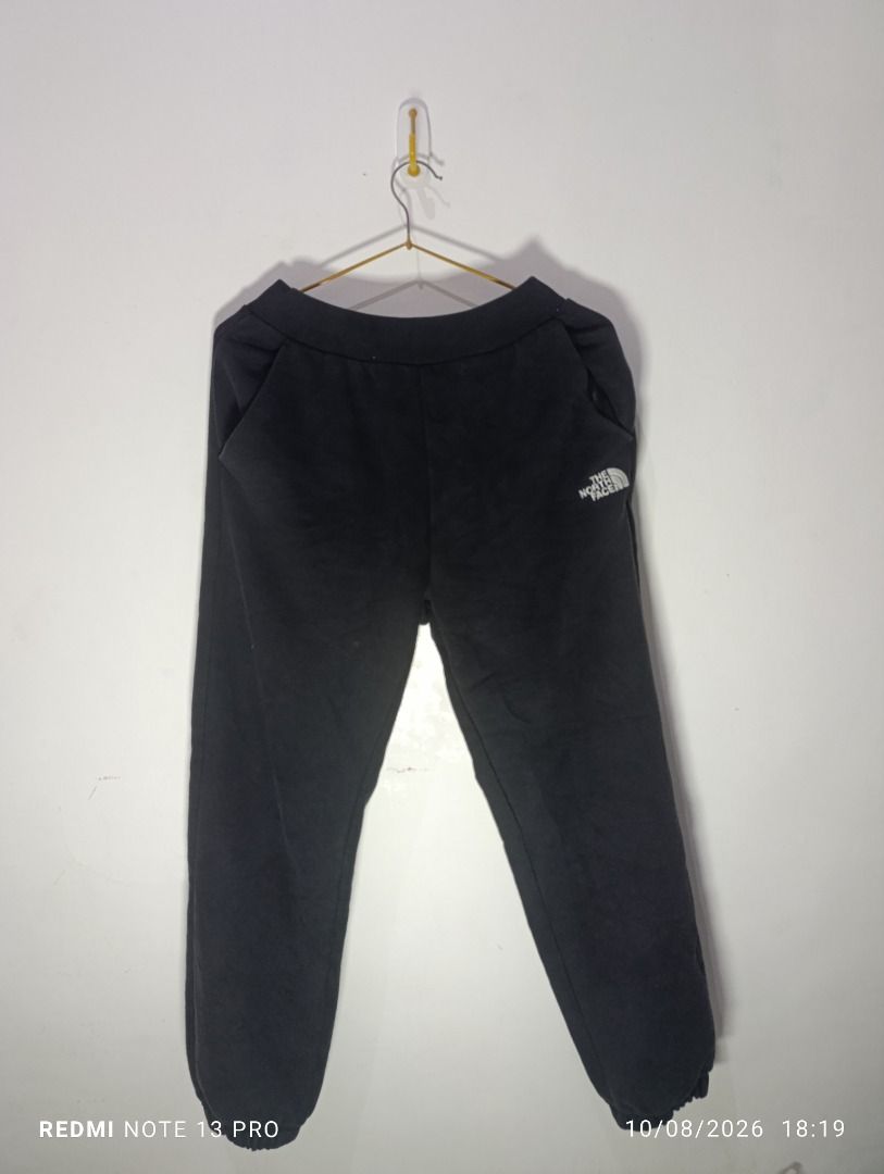 The North Face Black Sweatpants Joggers (Category: Joggers) located in Pasig City. Submitted by firstpick_thrift (Listing ID 1466772718, Image 2). Description: - Brand: The North Face - Color: Classic Black - Material: Soft and cozy fleece - Waistband: Ribbed with adjustable drawstring - Pockets: Two side pockets and one back pocket - Cuffs: Elastic at the ankles for a snug fit - Branding: Embroidered white logo on left hip and small logo patch o