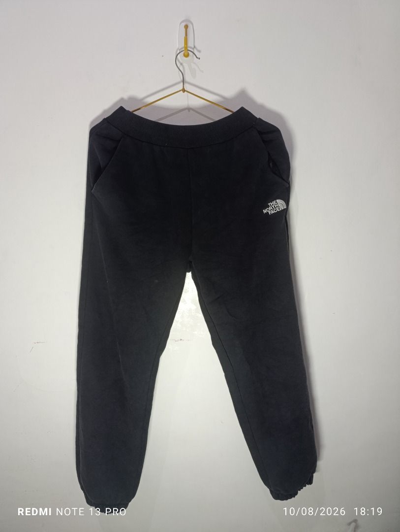 The North Face Black Sweatpants Joggers (Category: Joggers) located in Pasig City. Submitted by firstpick_thrift (Listing ID 1466772718, Image 1). Description: - Brand: The North Face - Color: Classic Black - Material: Soft and cozy fleece - Waistband: Ribbed with adjustable drawstring - Pockets: Two side pockets and one back pocket - Cuffs: Elastic at the ankles for a snug fit - Branding: Embroidered white logo on left hip and small logo patch o