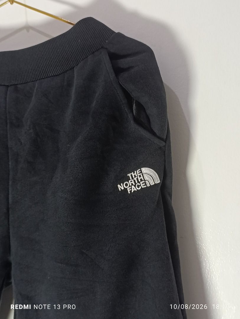 The North Face Black Sweatpants Joggers (Category: Joggers) located in Pasig City. Submitted by firstpick_thrift (Listing ID 1466772718, Image 3). Description: - Brand: The North Face - Color: Classic Black - Material: Soft and cozy fleece - Waistband: Ribbed with adjustable drawstring - Pockets: Two side pockets and one back pocket - Cuffs: Elastic at the ankles for a snug fit - Branding: Embroidered white logo on left hip and small logo patch o