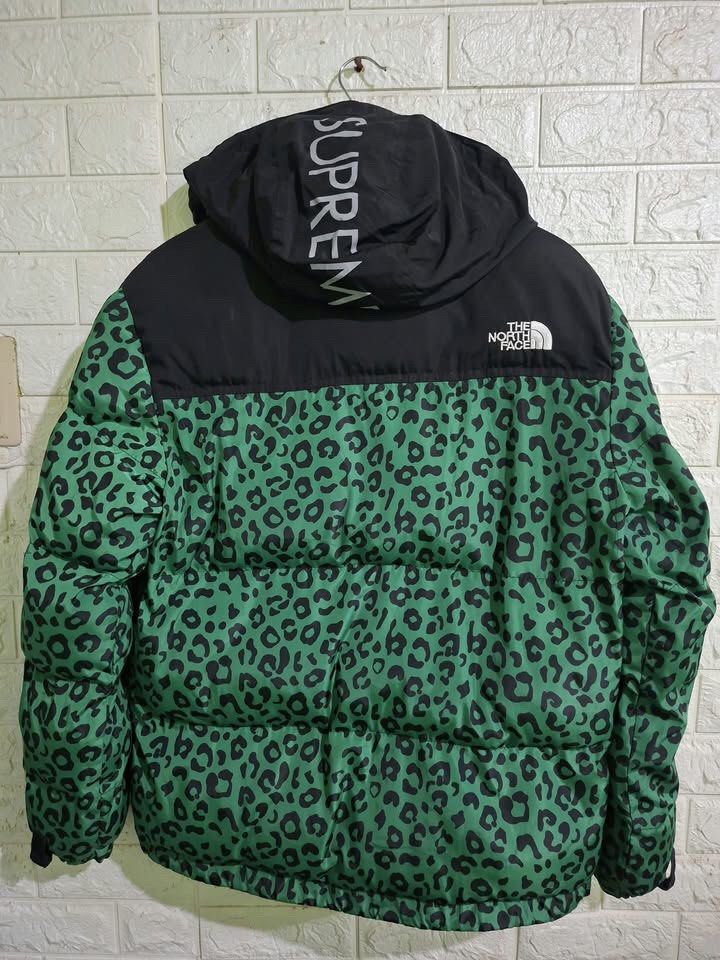 The North Face x Supreme Puffer Jacket (Category: Coats, Jackets and Outerwear) located in Bulacan. Submitted by bleue.finds (Listing ID 1466704975, Image 2). Description: The North Face x Supreme Puffer Jacket 22 - width 27.5 - length good condition mino slice bandang zipper no other issues reflectorize yung hood nya na may naka sulat na supreme.
