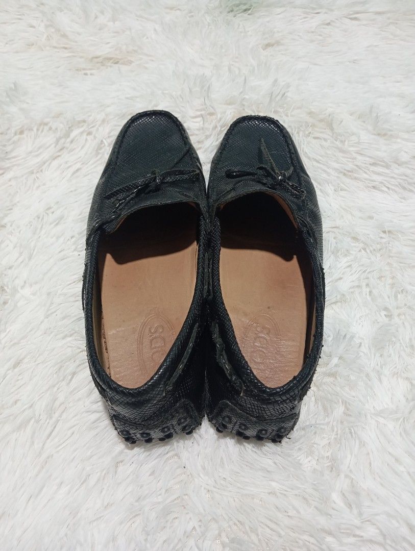 Tod's Loafers (Category: Sneakers & Footwear) located in Quezon City. Submitted by thesecondmarketph (Listing ID 1466759608, Image 3). Description: - Brand: Tod's - Style: Slip-on driving shoes / moccasins - Color: Black - Material: Textured leather with signature rubber pebble soles and heels - Size: 10.5 (Made in Italy) - Details: Classic bow detail on top - Condition: Shows normal wear on the inner lining and soles from regular use, but still 