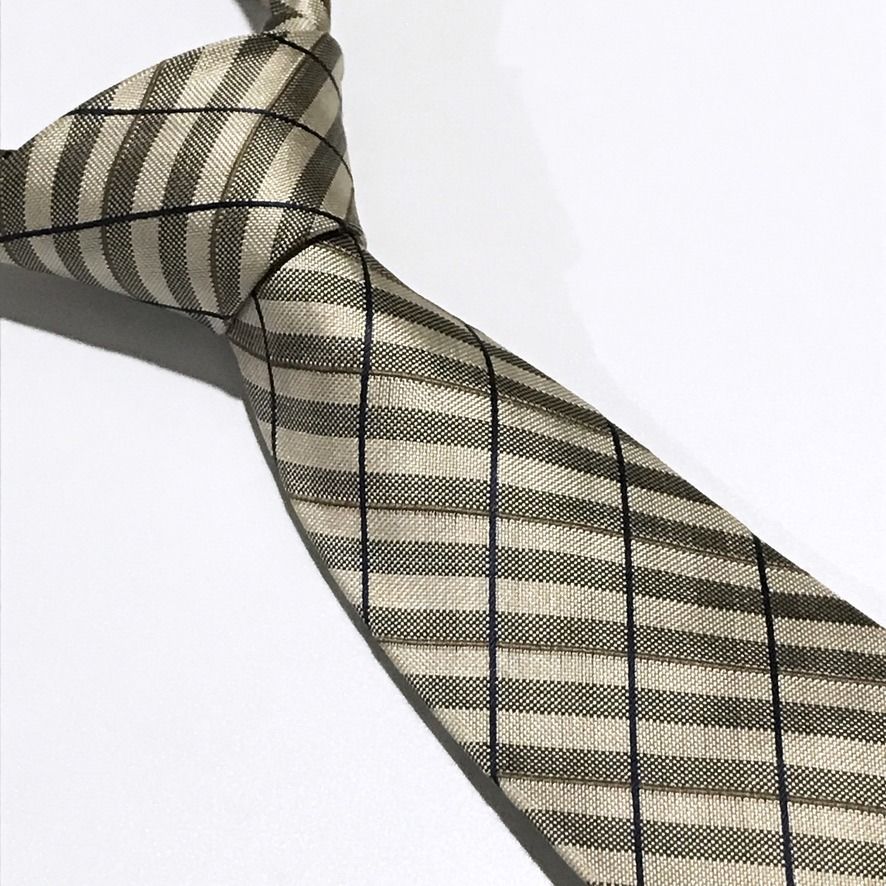 TOPVALU Woven Checkered Beige Neck Tie (Category: Ties) located in Taguig. Submitted by retrogaze (Listing ID 1466678990, Image 1). Description: This 100% silk necktie by TOPVALU features a beige base woven with a rich, multi-textured geometric grid structure. The design displays alternating ribbed and micro-textured diagonal bands framed by subtle olive-green pinstripes and crisscrossing navy blue windowpane lines. Brand Overview: TOPVALU is a w