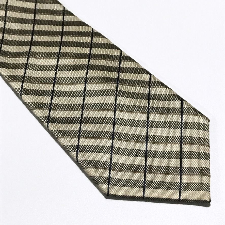 TOPVALU Woven Checkered Beige Neck Tie (Category: Ties) located in Taguig. Submitted by retrogaze (Listing ID 1466678990, Image 2). Description: This 100% silk necktie by TOPVALU features a beige base woven with a rich, multi-textured geometric grid structure. The design displays alternating ribbed and micro-textured diagonal bands framed by subtle olive-green pinstripes and crisscrossing navy blue windowpane lines. Brand Overview: TOPVALU is a w