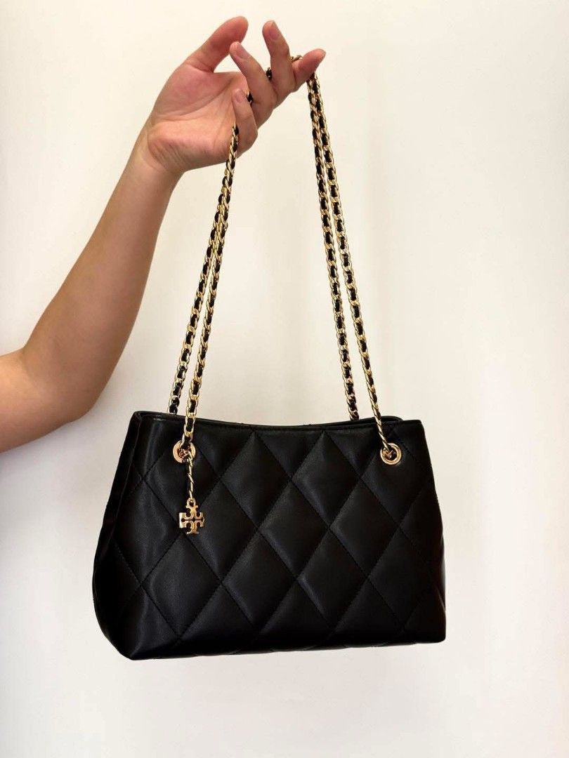 Tory Burch Fleming Quilted Carryall Bag (Category: Shoulder Bags) located in Paoay. Submitted by rvf1230 (Listing ID 1466596033, Image 1). Description: Black quilted leather shoulder bag from Tory Burch. Gold-tone chain straps and hardware. Includes a hanging logo charm. Interior zipped pocket with fabric lining. Can be worn on the shoulder or handheld by tucking the straps inside. Clean inside and out, minor wear on the leather..